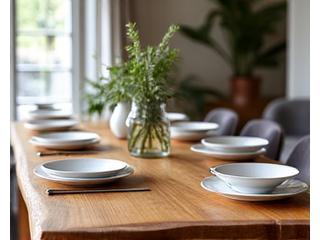 A rustic-chic dining table crafted from reclaimed wood, set with simple white ceramic dishes, highlighting natural wood aesthetics in home decor.